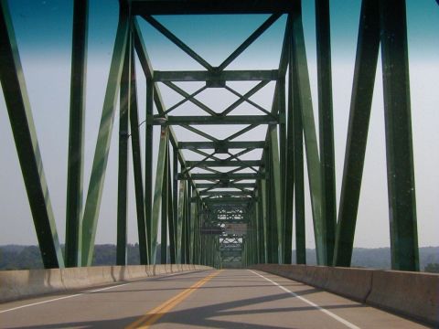 1994 Ford Probe - Driving across a green truss bridge, with the road and concrete barriers visible ahead.