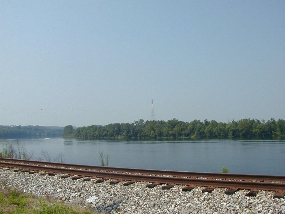 Waterway with trees and railroad tracks