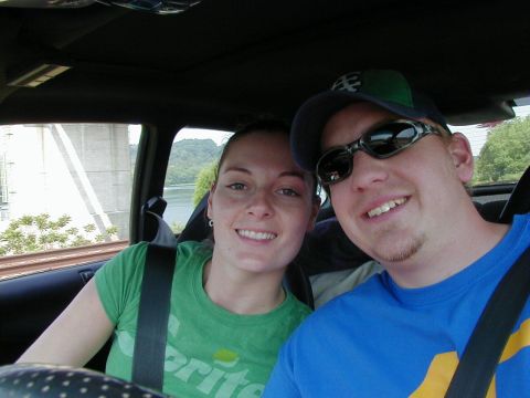 1994 Ford Probe - A couple takes a selfie while riding in a car, with a scenic view of a bridge and water outside.