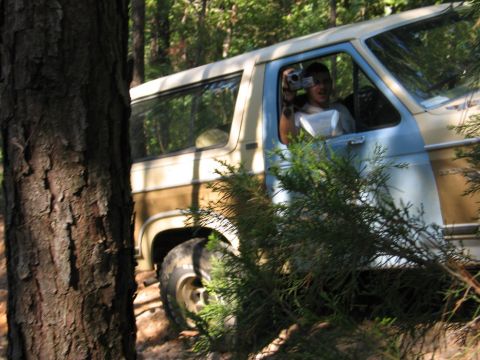 1995 Ford Bronco - A person films from the driver's seat of a vintage Ford Bronco navigating a wooded trail.