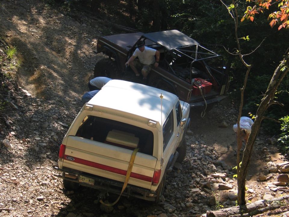 White Bronco and a brown off-road vehicle on a rocky trail