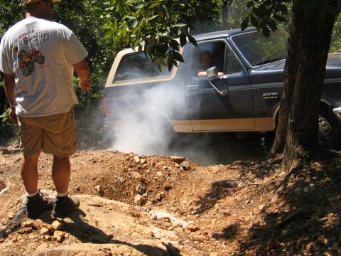 1995 Ford Bronco - Ford Bronco tackles a challenging off-road obstacle, generating smoke from its tires.