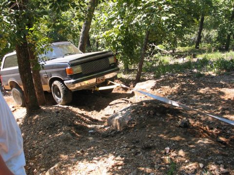 1995 Ford Bronco - Ford Bronco navigating a challenging off-road trail with a tow strap engaged.
