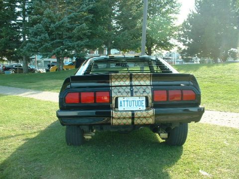 1978 Ford Mustang II - The rear of a black 1978 Ford Mustang II is shown with a distinctive gold stripe pattern and a personalized license plate.