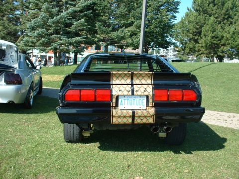 1978 Ford Mustang II - Rear view of a black 1978 Ford Mustang II with a distinctive gold stripe and custom license plate.