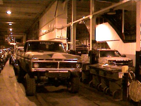 1977 Ford F-150 - A camouflaged 1977 Ford F-150 pickup truck is parked indoors next to other vehicles.