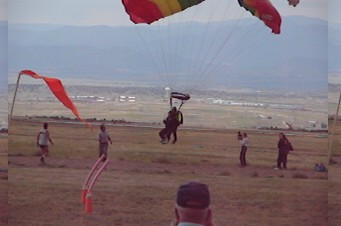 1972 Ford Ranchero - A group of skydivers are landing in a wide open field with a few spectators watching.