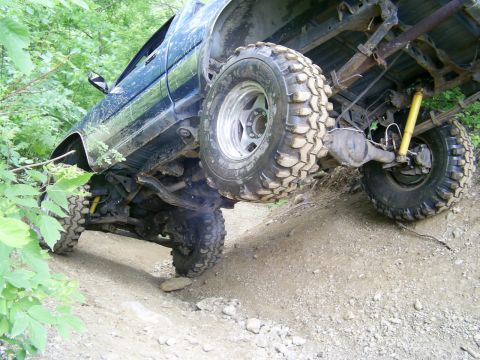 1977 Ford F-150 - Truck is navigating a steep, rocky dirt trail with its wheels at an angle.