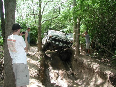 1977 Ford F-150 - A Ford F-150 tackles a challenging off-road obstacle with steep inclines and mud.