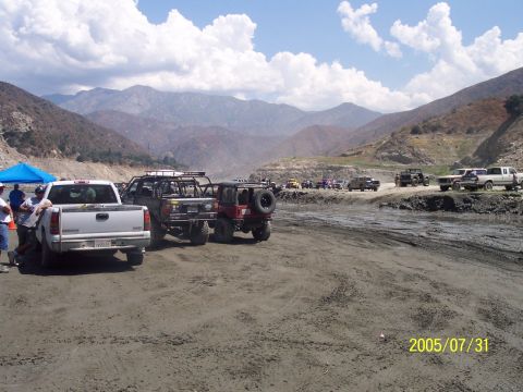 1985 Ford Bronco - A collection of off-road vehicles are parked in a dry, dusty landscape with mountains in the background. The photo is dated July 31, 2005.