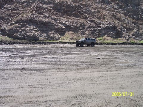 1985 Ford Bronco - A silver SUV is parked in a dirt lot with a rocky hillside in the background. The date stamp reads 2005/07/31.