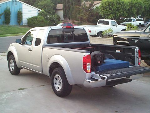 2005 Nissan Frontier - Silver 2005 Nissan Frontier pickup truck with a black dog resting in the bed.