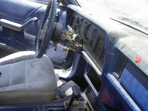 1982 Ford Mustang - The interior of a 1982 Ford Mustang is visible, with a blue dashboard and worn seat.