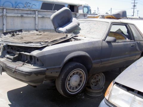 1982 Ford Mustang - This car appears to be a Ford Mustang from the late 1980s, possibly a 1987 model, in a state of disrepair.