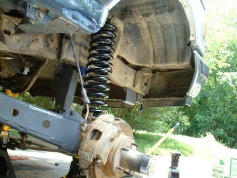 1991 Ford Bronco - The front suspension and coil spring of a 1991 Ford Bronco are visible during an installation process.
