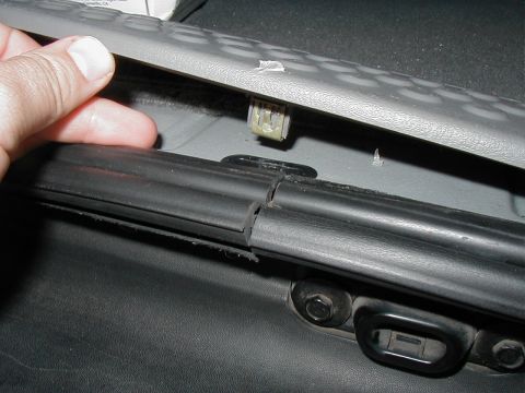 2002 Ford Excursion - Close-up of a broken interior trim clip and rubber seal, likely from a vehicle door or panel.