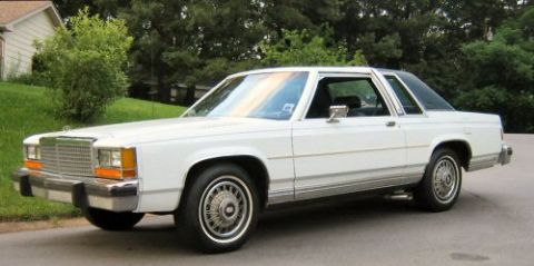 1985 Ford Crown Victoria LTD - A white 1985 Ford Crown Victoria LTD two-door sedan is parked on a residential street.