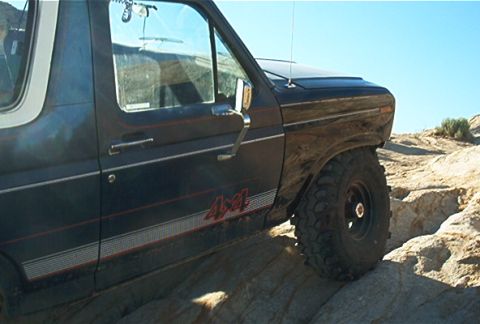 1986 Ford Bronco - 1986 Ford Bronco navigating rough, rocky terrain off-road.