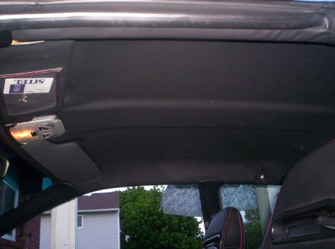 1993 Ford Probe - The interior of a car is shown, focusing on the headliner and overhead console area, with a pocket on the sun visor holding a card.