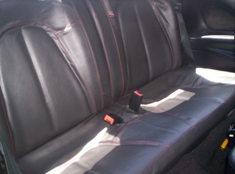1993 Ford Probe - The interior rear seats of a car feature black upholstery with contrasting red stitching and visible seatbelts.