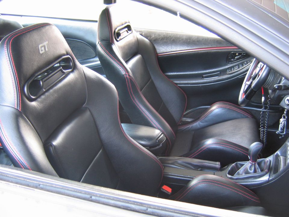 Black leather bucket seats with red stitching and GT badging in a 1993 Ford Probe