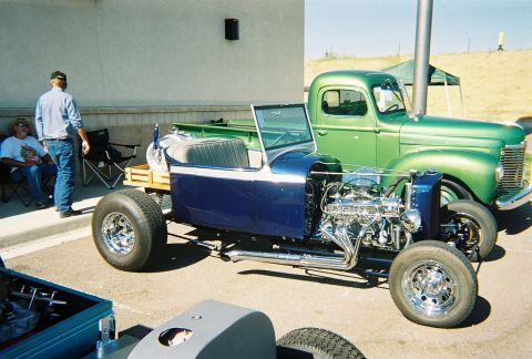 1972 Ford Ranchero - Two custom vehicles, a blue roadster and a green pickup, parked outdoors.