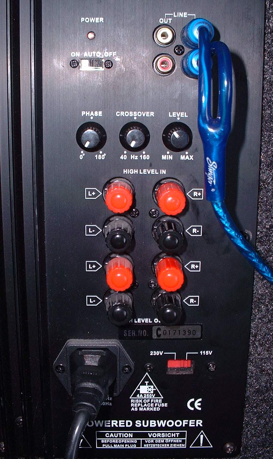 Powered subwoofer amp panel with phase, crossover and level knobs, RCA jacks, blue Stinger cable and speaker terminals