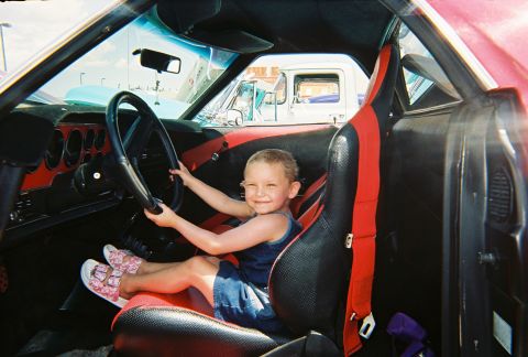 1972 Ford Ranchero - A young child plays driver inside a vehicle, with another truck visible through the windshield.