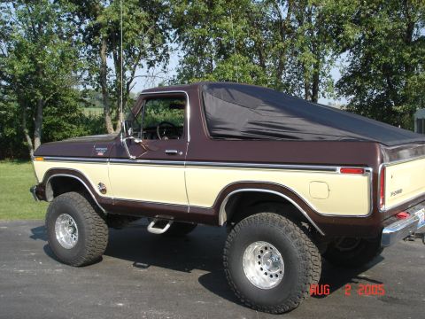 1979 Ford Bronco - This two-tone brown and tan 1979 Ford Bronco features a black soft top and is shown from the side.