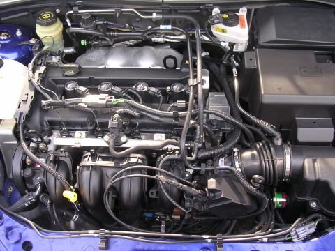1985 Ford Bronco - A close-up view of a car's engine bay, showing intricate mechanical details and wiring.