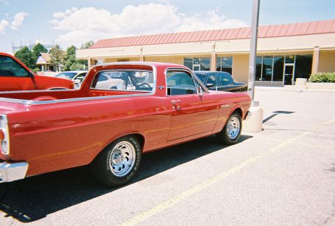 1972 Ford Ranchero - A red 1972 Ford Ranchero is parked in a lot next to another vehicle.
