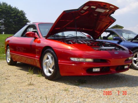 1995 Ford Probe - A red 1995 Ford Probe is parked with its hood open, revealing the engine bay.