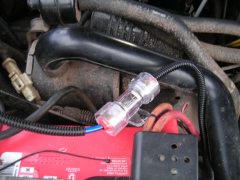 1994 Ford Bronco - Close-up of an inline fuse holder installed in a vehicle's engine bay, connected to the battery terminals.