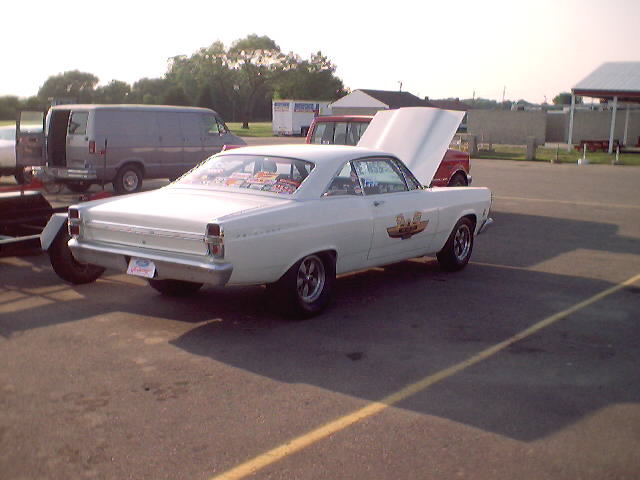 White 1967 Ford Fairlane coupe with hood open, racing decals on door