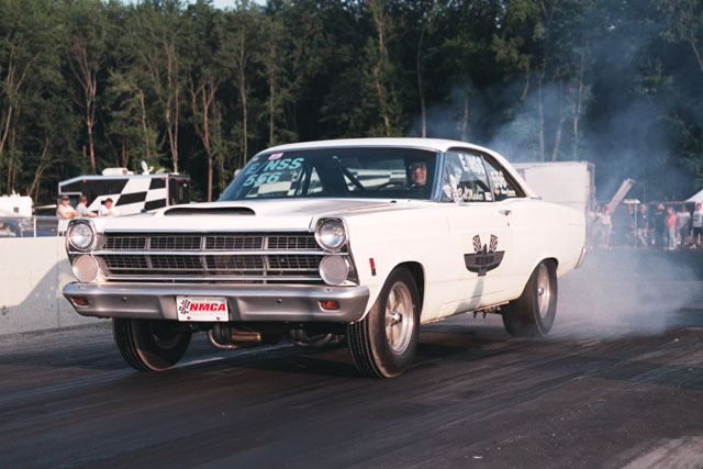 White 1967 Ford Fairlane doing a burnout on a drag strip