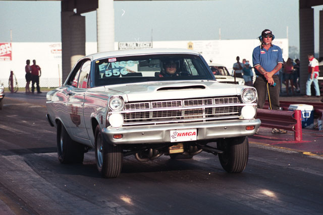 White 1967 Ford Fairlane drag car with hood scoop, NMCA badge, and racing numbers on windshield