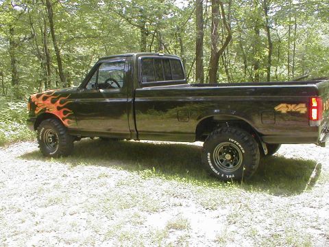 1991 Ford F-150 - This 1991 Ford F-150 pickup truck features flame decals on the front fender and 4x4 badging on the rear quarter panel.