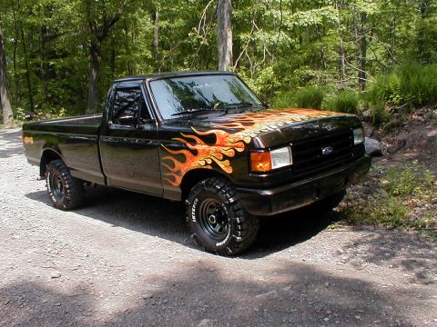 1991 Ford F-150 - Black 1991 Ford F-150 pickup truck with custom flame graphics parked outdoors.