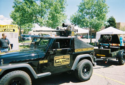 1972 Ford Ranchero - A modified Jeep Wrangler with a Gatling gun and a towed weapon system is displayed at an outdoor event.