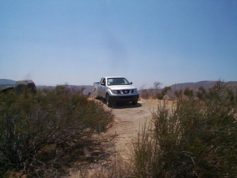 2005 Nissan Frontier - Silver 2005 Nissan Frontier pickup truck seen off-road under a clear blue sky.