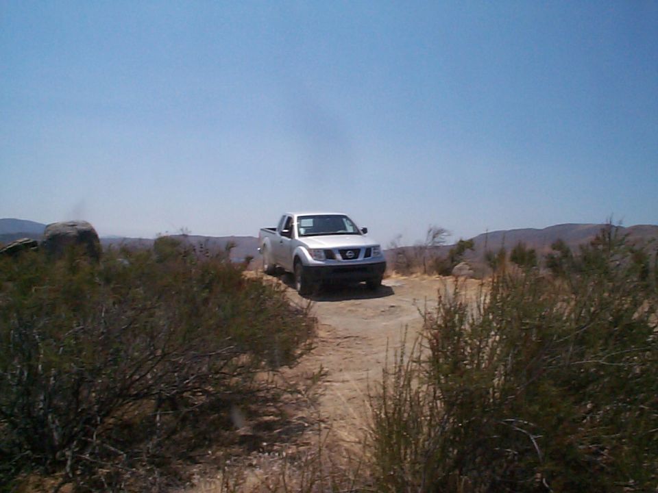 2005 Nissan Frontier parked on a dirt road in a dry, brushy landscape