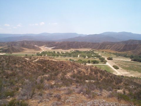 2005 Nissan Frontier - A vast valley landscape unfolds under a clear blue sky, with rolling hills and distant mountains.