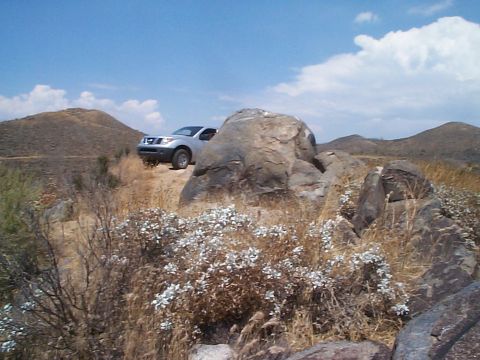 2005 Nissan Frontier - Silver 2005 Nissan Frontier parked off-road in a dry, rocky terrain under a blue sky.