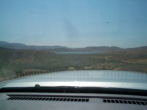 2005 Nissan Frontier - View from inside a vehicle looking out at a distant lake and rolling hills.