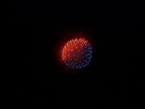 2005 Nissan Frontier - Fireworks light up the night sky with a burst of red and blue sparks.