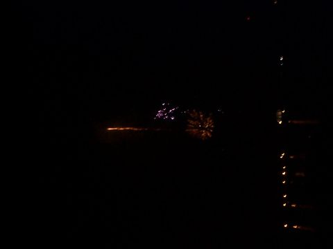 2005 Nissan Frontier - Nighttime fireworks display with distant lights visible on the horizon.