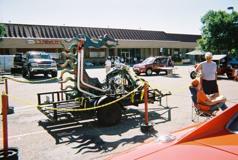 1972 Ford Ranchero - A custom motorcycle trailer with a dragon theme is displayed at an outdoor event, with other vehicles and people in the background.
