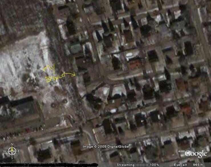 Aerial view of a suburban neighborhood with a yellow arrow and text 'my BRONCO' pointing to a vehicle
