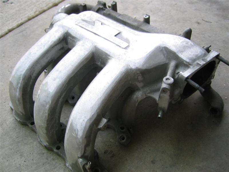 Aluminum intake manifold with four runners and a rectangular plate on top