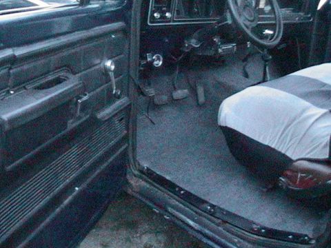 1977 Ford F-250 - Interior view of a truck cab, revealing the driver's side door panel, dashboard, and seat.